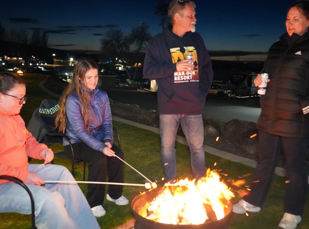 Guests around a campfire at dusk at MarDon Resort