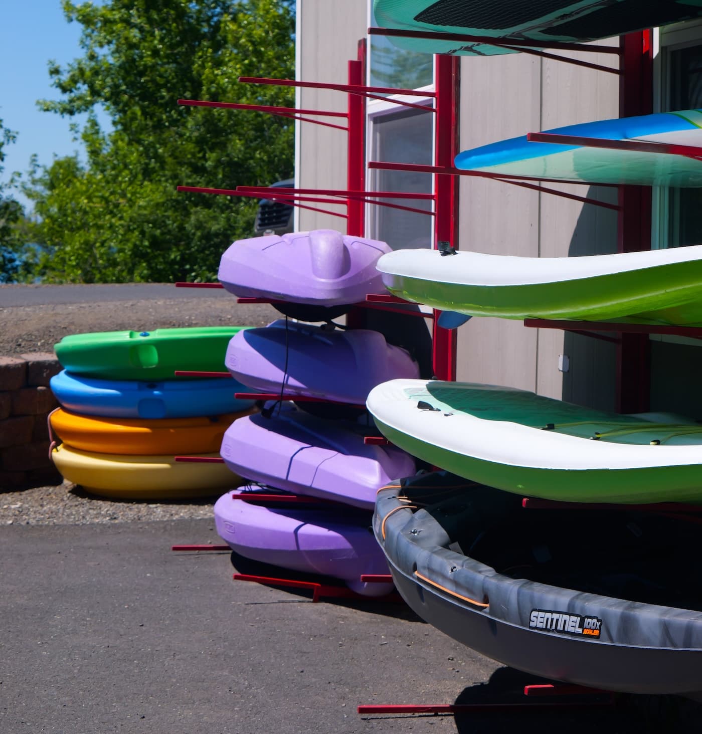 Kayaks and paddle boards stacked on the rental rack at the resort